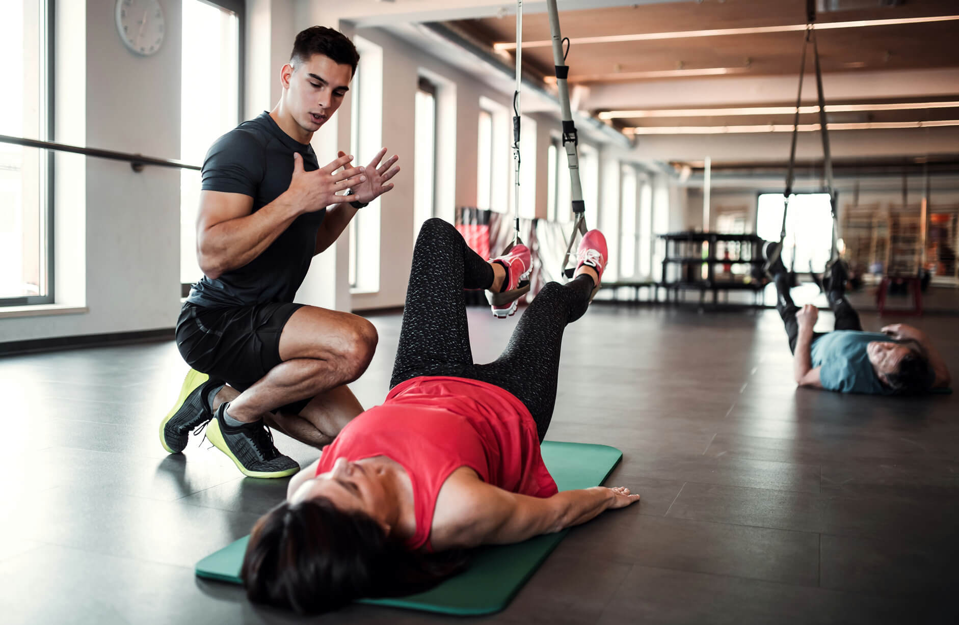 Personal trainer assisting a woman with her corrective exercise plan.